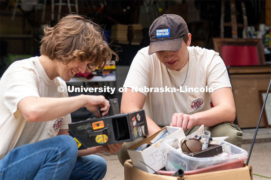 Phi Kappa Theta members Ryan Richter (left) and Isaac Alfieri (right) look through a box of antique trinkets and miscellaneous items during the Big Event. May 4, 2024. Photo by Kirk Rangel for University Communication.